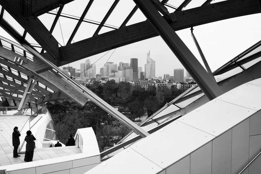 Komplexe Struktur eines modernen Gebäudes in Berlin mit der Skyline der Stadt im Hintergrund, fotografiert von einem Architekturfotografen.