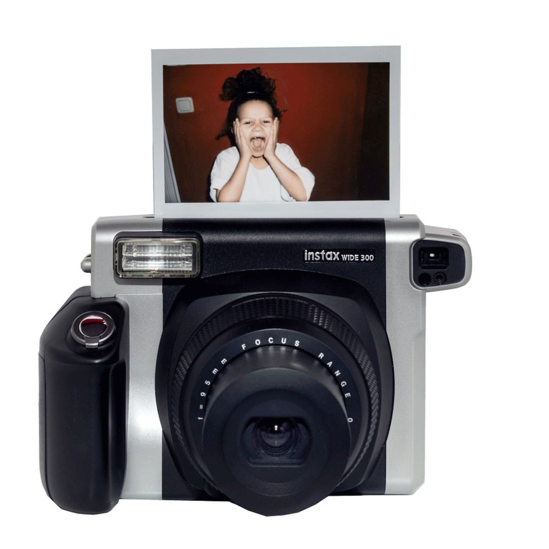 Eine Instax-Kamera druckt ein Sofortbild eines lachenden Kindes aus, das den kreativen Einsatz von Polaroid- und Instax-Passepartouts auf Veranstaltungen in Berlin zeigt.