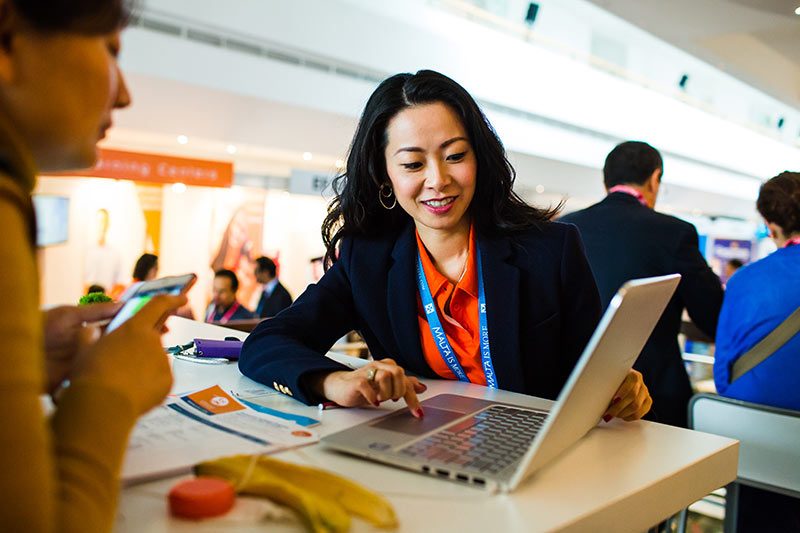 Kongressfotograf Berlin dokumentiert eine Teilnehmerin beim ICEF Workshop im Gespräch vor einem Laptop.