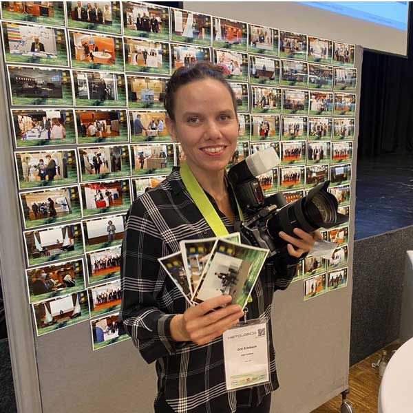 Fotografin in Berlin druckt Veranstaltungsfotos sofort aus und h&auml;lt diese zusammen mit ihrer Kamera in der Hand.